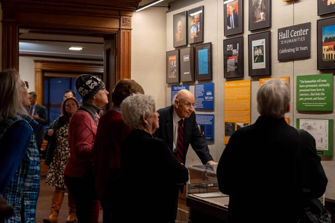 A group of Hall Center supporters view the gallery wall of Hall Center history at the Watkins exhibit.