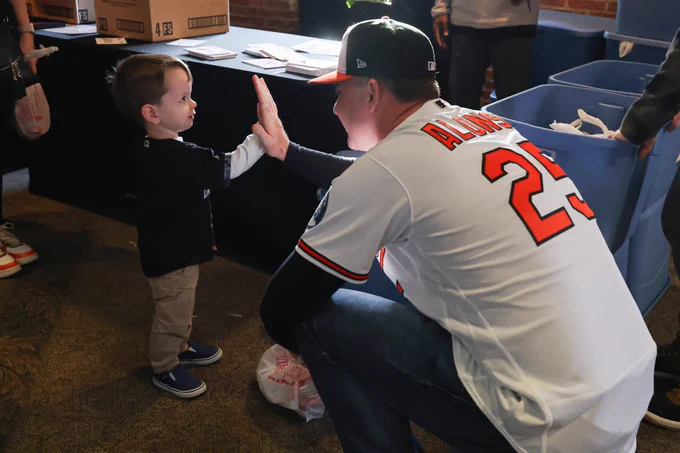 Pete Alonso high fives a young fan at a community event.