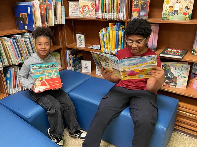 Two children reading Mathical Books at their school library, winner of a 2025-26 Mathical Collection Development Award