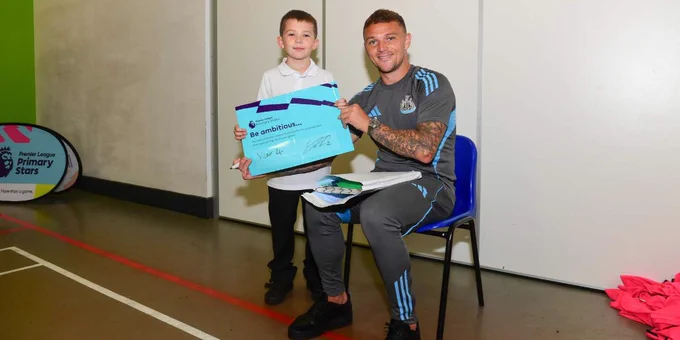 Kieran Trippier presenting a certificate to a young recipient at a Premier League Primary Stars event indoors.
