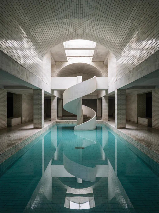 A surreal empty space of [LOCATION], endless corridors and rooms, liminal lighting, no people, soft fluorescent glow, dreamlike atmosphere, unsettling calm