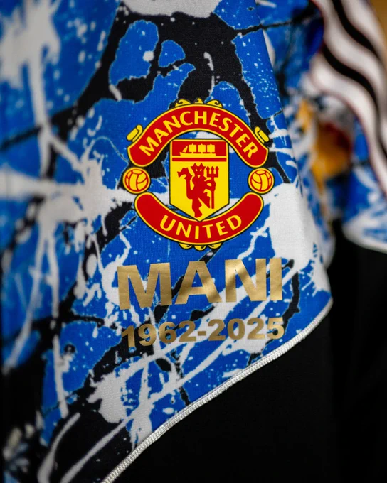 Close-up of a Manchester United jersey featuring the name 'Mani' and years 1962-2025 on a blue and white patterned background.