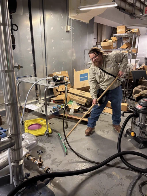Employee sweeping in a maintenance room at UT Austin