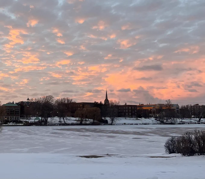 Pink cloudy winter sky over a frozen river