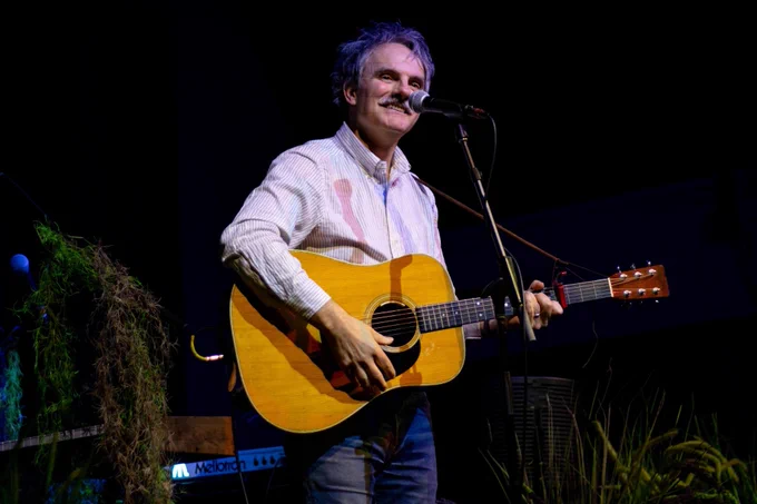 Image shows Mike Viola performing on stage with a guitar. Photo by Allie Castaneda.