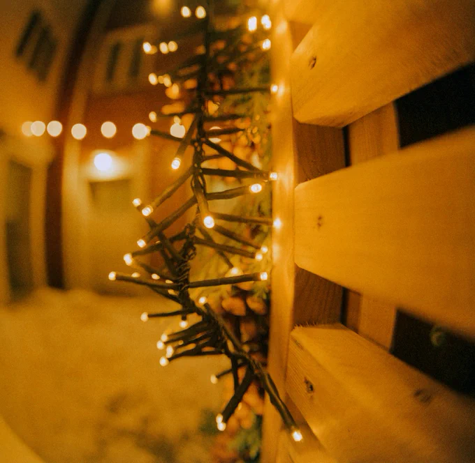 Closeup of Christmas lights hanging outside with blurry background.