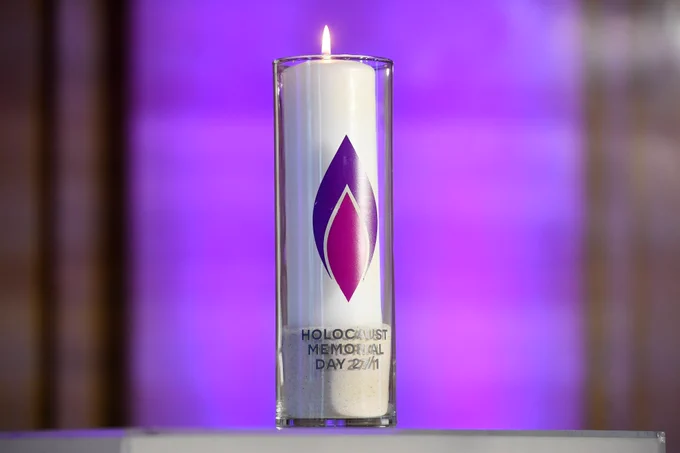 The lighted white Candle featuring the purple flame logo of the HMD.