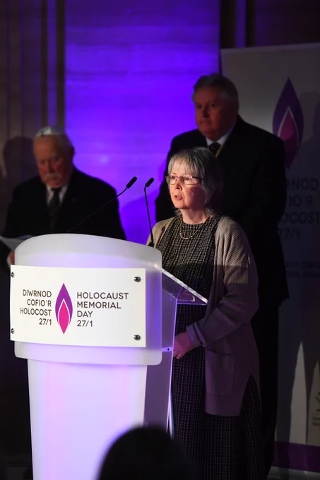 Rhian stands at the lectern which depicts the HMD logo and reads a reflection on behalf of Disability Wales