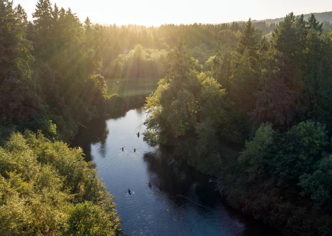 An image of folks kayaking on the Tualatin River with a beautiful sunrise.
 