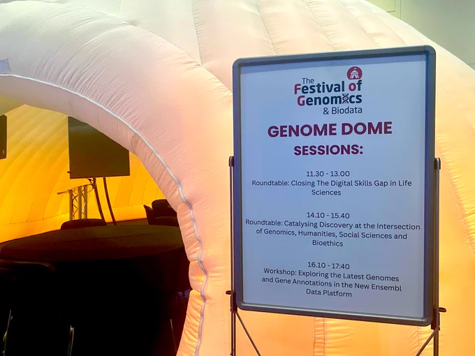 Photographs of the Festival of Genomics banner and Genome Dome session agenda.