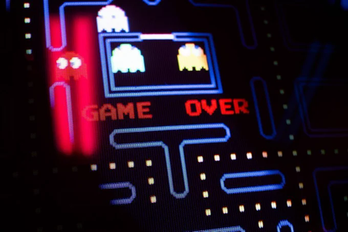 Closeup of the "Game Over" screen on a Pac-Man arcade game.