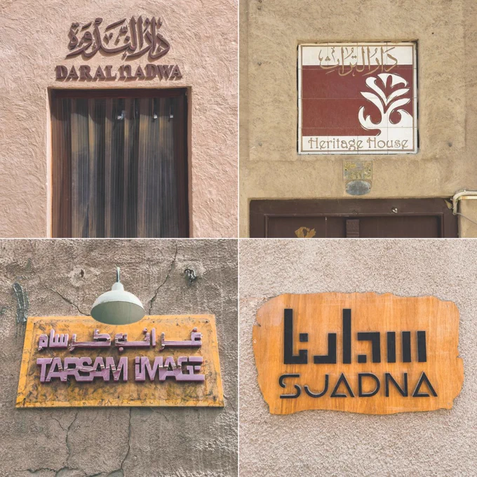 Four photographs displaying multiscript shop signs against textured wall backgrounds in Dubai's Al Fahidi Historical Neighborhood.