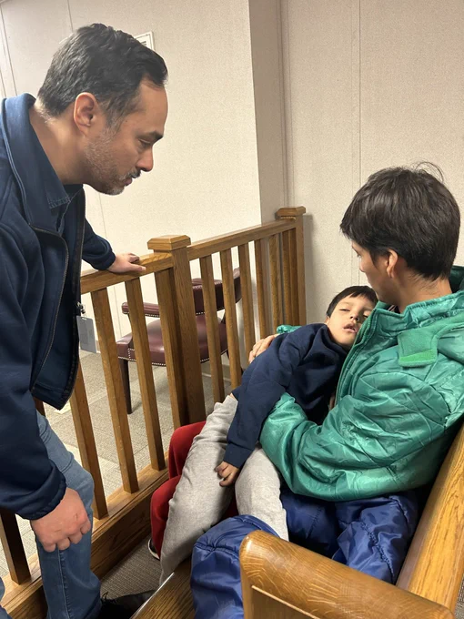Photo of Liam Ramos listless in his dad’s arms. Congressman Joaquin Castro is with them