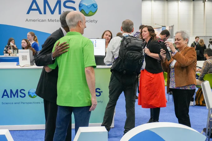 AMS past president Anjuli Bamzai taking photo of president Alan Sealls at the Meet the President event at the AMS Booth.