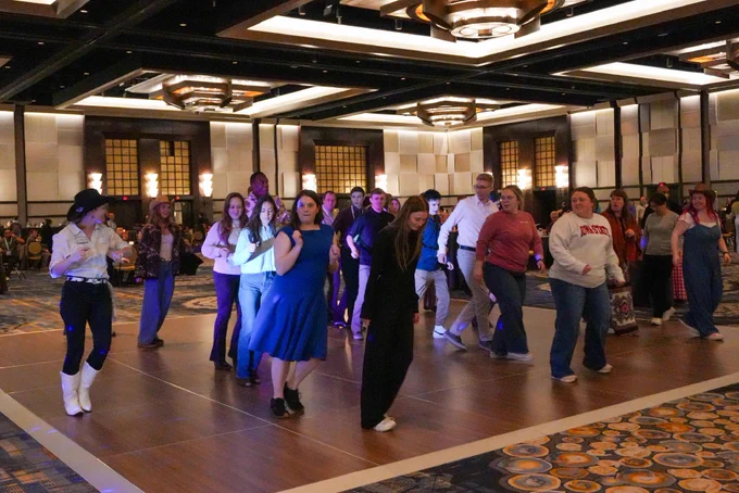 Attendees line dancing at the Wednesday Night Live event.