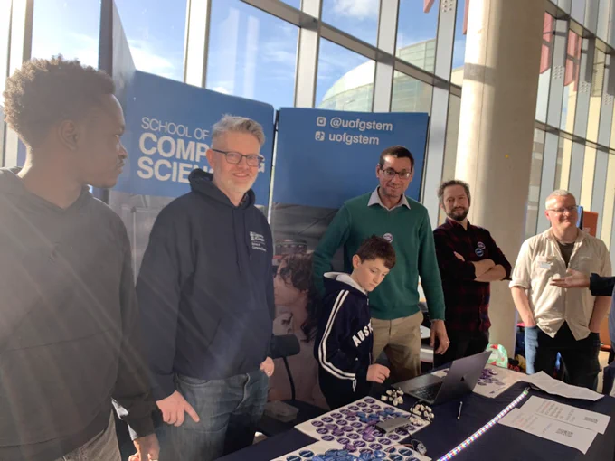 Computing Science academic staff members and students at a Open Day stand