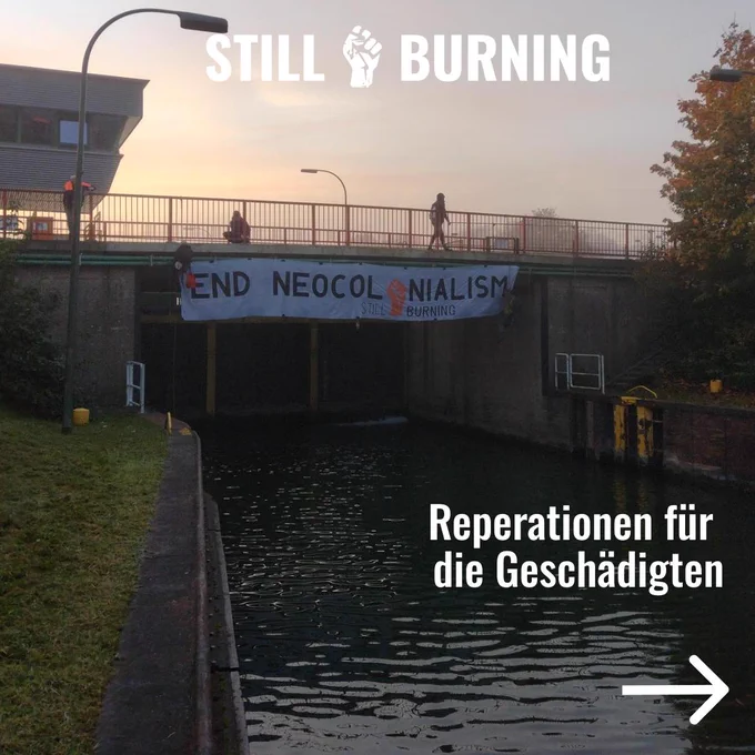 Sharepic mit einem Bild eines Banners über der Schleuse im Hintergrund. Aufschrift: "Reparationen für die Geschädigten"