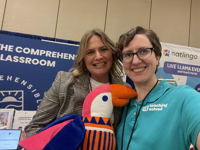 Hope and Martina Bex with a plushie of Bonzo the parrot in front of the comprehensible classroom booth