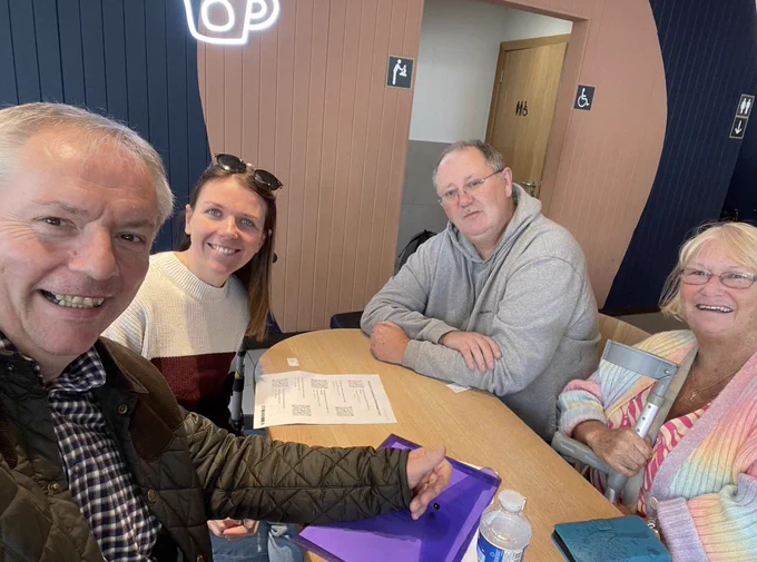 Members of the Scottish Stammering Network smiling at the camera, sitting around a table