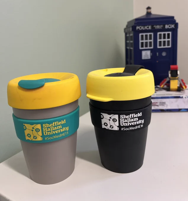 Two mugs with Sheffield Hallam University on them and the @SocMedHE conference logo and hashtag
