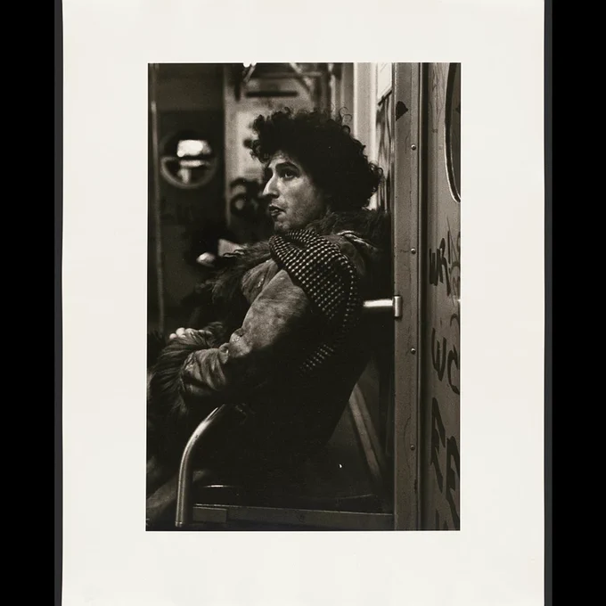 A subway passenger leaning against the wall.