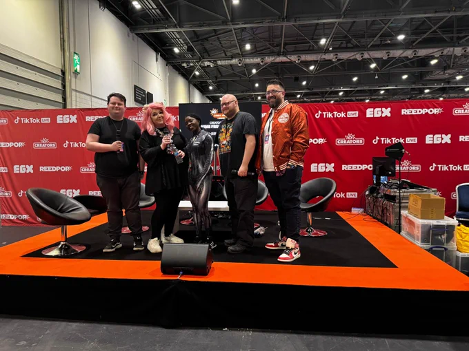 The panel stood up and posing for a picture in front of the stage