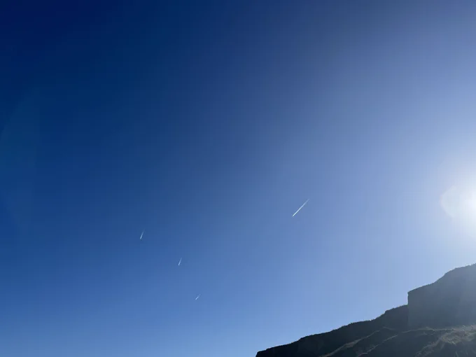 Planes like shooting stars against a very blue sky
