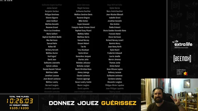 A long list of names, including mine (Mathieu Hunter). There is a timer for Total Time Played standing at 10 hours, 26 minutes and 3 seconds. There are logos on the right side of the screen: Extra-Life, Beenox, and Opération Enfant-Soleil.

On the bottom-right corner of the screen, my webcam is showing me smiling and making a peace sign. I have a charcoal shirt, a big beard and a black headset on my head. Books and video games can be seen on a bookshelf behind me, and a window.