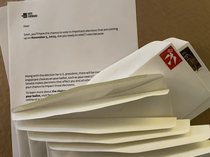 The image is a photo of a stack of form letters and envelopes. The form letter says "Soon, you'll have the chance to vote in important elections that are coming up on November 5, 2024. Are you ready to vote? I vote because" and then there is a blank for the letter-writer to fill in.