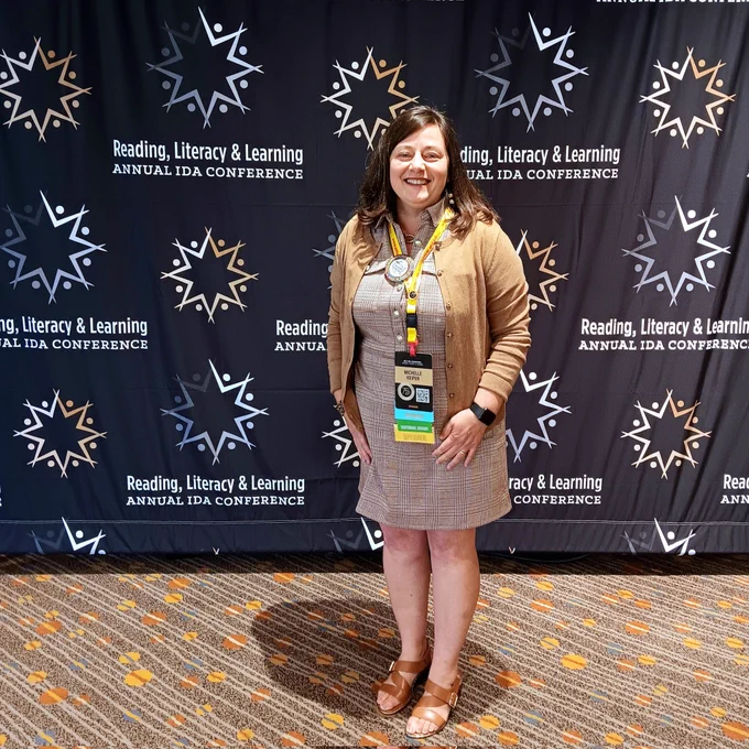 Michelle Keiper poses in front of the IDA conference backdrop.