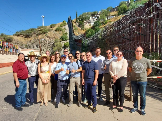 While visiting Arizona, participants of the International Visitor Leadership Program focused on "Regional Collaboration in Combating Transnational Crime" take a group photo at the U.S.-Mexico border. 