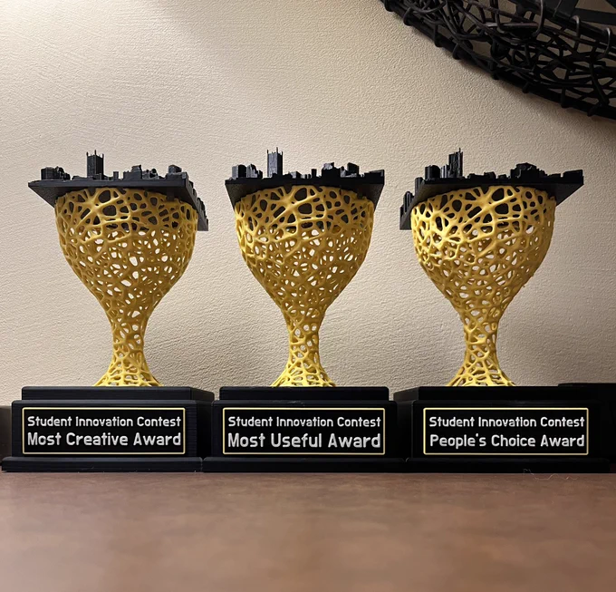 Three 3D-printed trophies for SIC awards.
