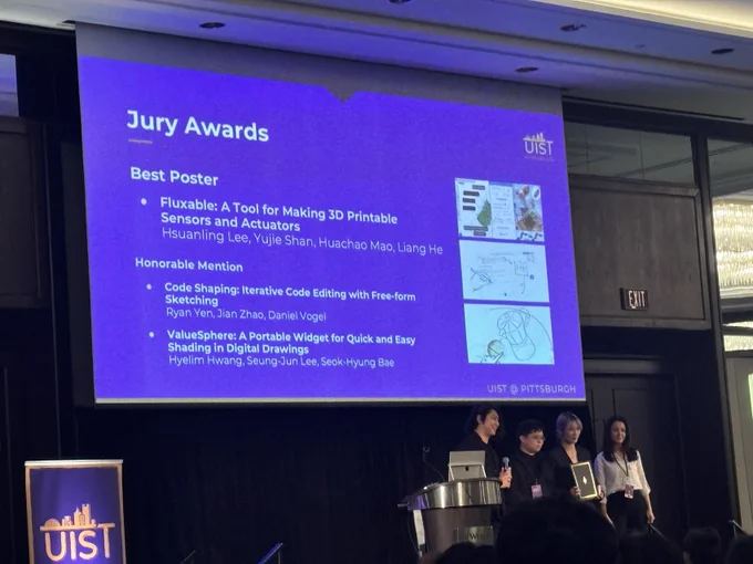 Hannah and Liang receive the best poster award on stage.