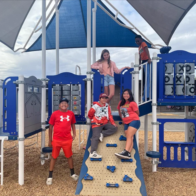 Five students are playing on a playground at John McCandless