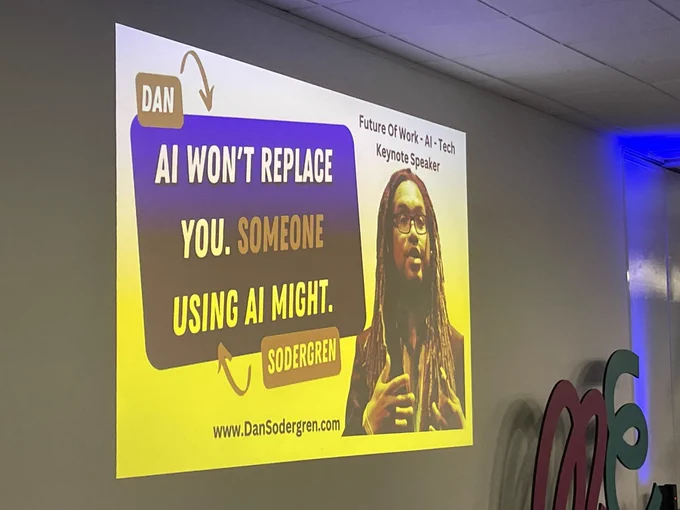 A slide on a projector saying “AI won’t replace you. Someone using it might.”