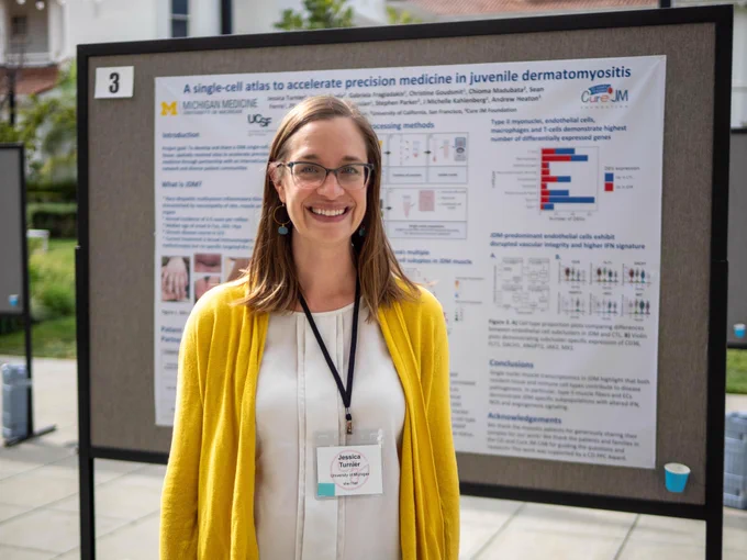 Person standing in front of poster smiling