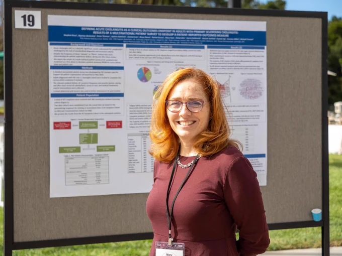 Person standing in front of poster smiling