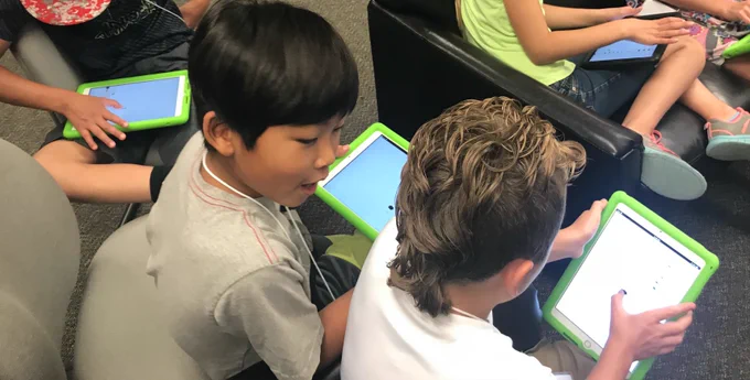 youth working on a collaborative activity on iPads