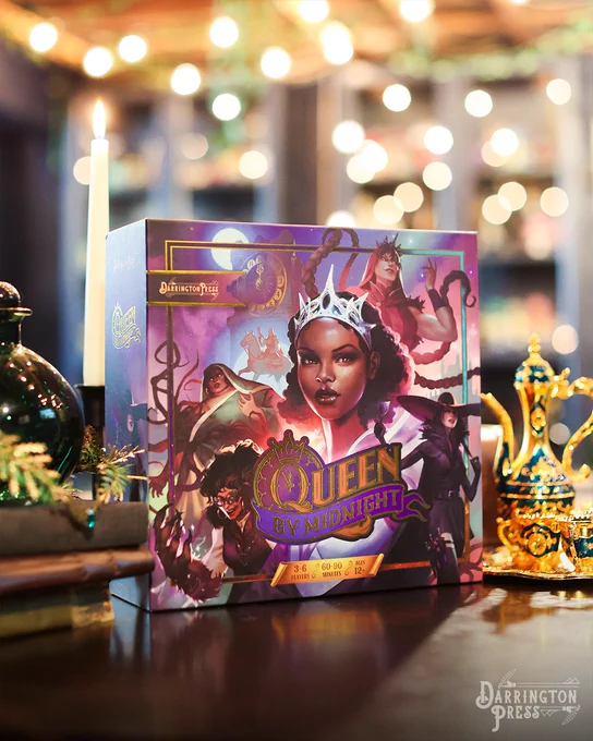 Darrington Press's competitive deck builder board game Queen by Midnight. Game Box sitting upright on a table.