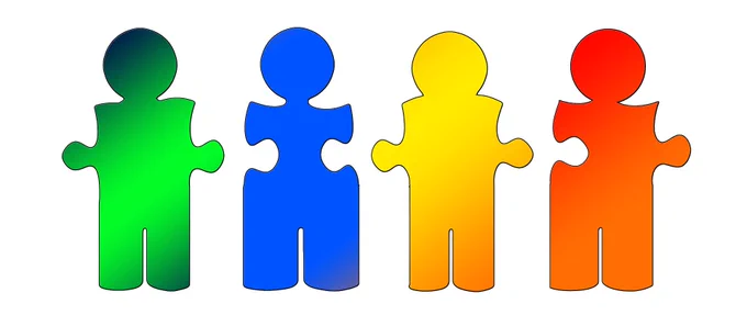 Four different coloured puzzle pieces in the shape of people next to each other about to join.