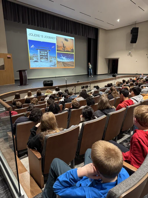 Students in audience listening to woman on stage