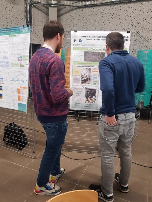 Eric Bourrianne discutant les résultats du poster "Particle Size Magnifier (PSM) at ATOLL for Ultra Fine Particle measurements" avec un collègue