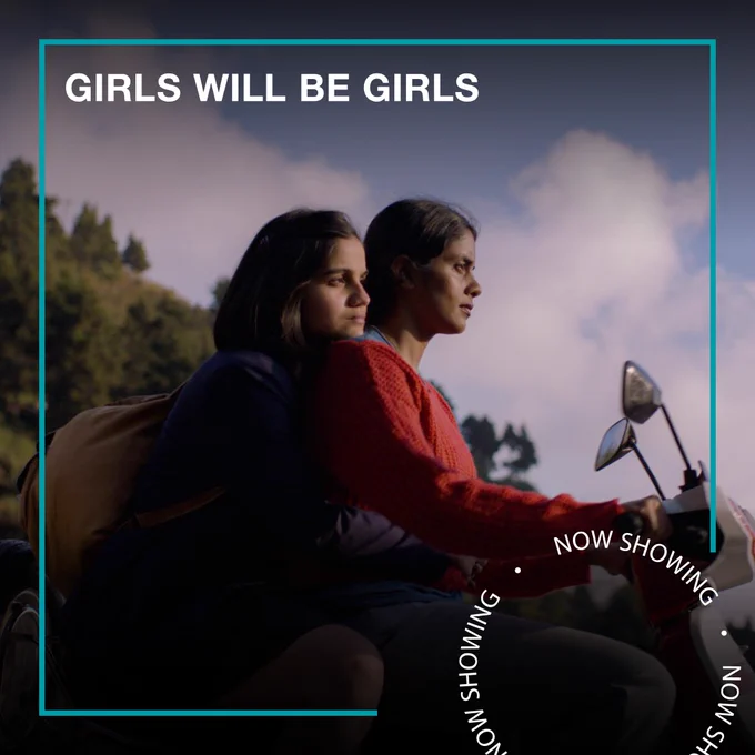 Two women ride on a motorcycle together. Text - Girls Will Be Girls, Now Showing