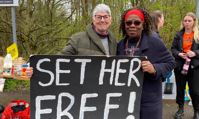 Two women holding a large sign saying 'SET HER FREE!'