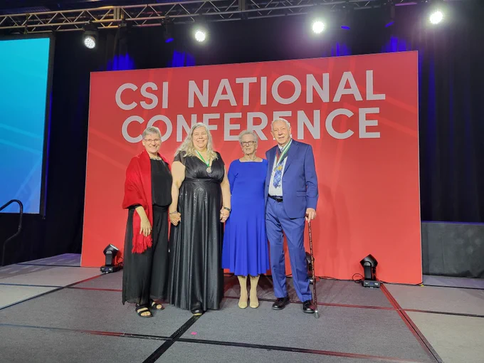 4 people on stage celebrating an award