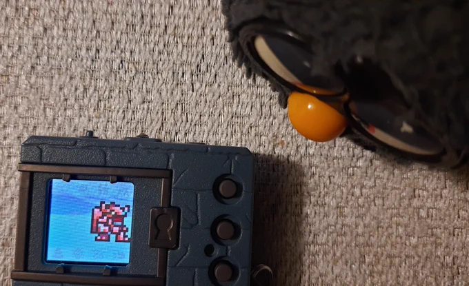 Smoky Furby staring at a Digital Monster Colour with a BlitzGreymon