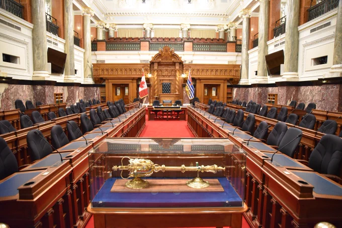 Legislative chamber with red carpet and rows of desks and chairs