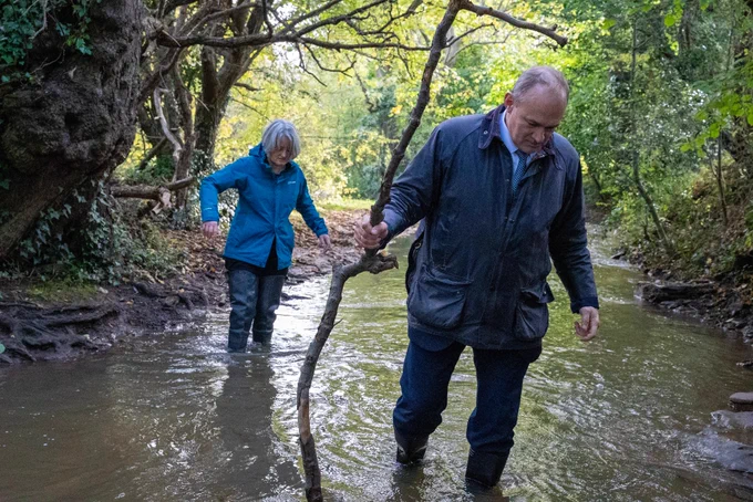 Ed Davey and Claire Young in the river Frome. 