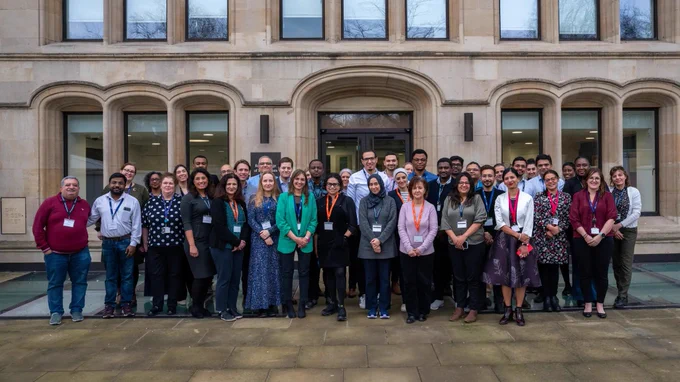 Group of diverse individuals posing for a photo in front of The Royal College of Radiologists building.