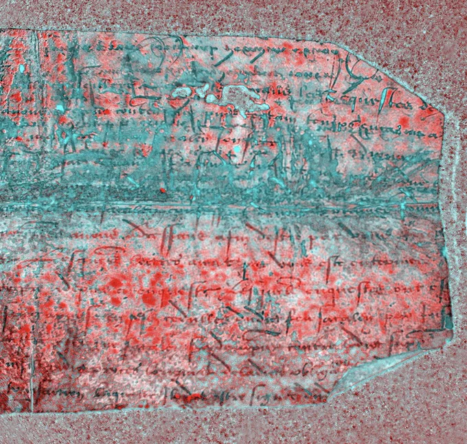 The edge of the same fragment of a medieval manuscript shown in the first photograph. This is a pseudocolour or false colour image produced via special imaging techniques and software manipulation. Here, the fragment is rendered in multiple shades of crimson, dark red, and turquoise, rendering the formerly illegible text legible.